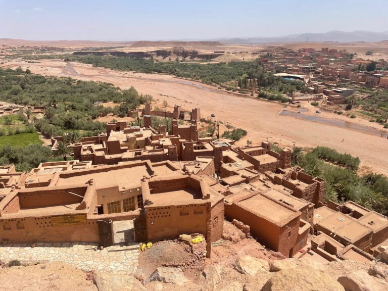 7 Day Desert Tour From Marrakech,Sunrise over Merzouga desert dunes with a camel caravan in Morocco." "Todra Gorge cliffs with a winding river, showcasing Morocco’s natural landscapes." "Traditional desert camp in the Sahara under a starry night sky." "Kasbah architecture along the route from Marrakech to the desert." "Colorful streets of the Blue City with mountain views in northern Morocco."