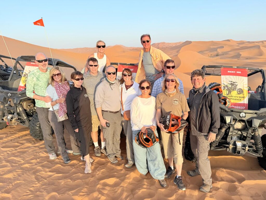 Marrakech Desert Tours,Golden sand dunes of the Sahara desert under a bright blue sky.,Spectacular sunset over the Erg Chebbi dunes, with silhouettes of camels,360-degree panoramic view of the vast, empty Sahara desert near Merzouga,Camel caravan trekking across the red sand dunes at sunset.,A friendly camel adorned with traditional Berber blankets for a desert tour,Small group of tourists enjoying a camel ride on their Marrakech desert tour,Luxury Berber desert camp with elegant tents under a starry night sky,Authentic nomadic-style tent with colorful rugs and cushions, Guests enjoying a traditional Moroccan dinner at a lantern-lit desert camp.,Group of Berber musicians playing drums around a campfire at a desert camp.,Adventurous traveler sandboarding down a steep sand dune,Visitor stargazing at the Milky Way from the Sahara Desert, no light pollution.,4x4 vehicle driving on the off-road tracks of the rocky desert near Zagora.,Winding road through the High Atlas Mountains on the journey from Marrakech.